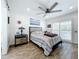 Bedroom features wood flooring, ceiling fan, and sliding barn door at 306 111Th E St, Bradenton, FL 34212