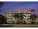 Three-story building exterior with palm trees and sunset view at 3430 77Th W St # 102, Bradenton, FL 34209
