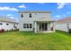 Home's backyard with green lawn and covered patio at 3543 Woodmont Dr, Parrish, FL 34219