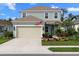 Two-story house with light green siding, beige garage door, and landscaped yard at 3543 Woodmont Dr, Parrish, FL 34219