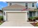 Attached two-car garage with American flag at 3543 Woodmont Dr, Parrish, FL 34219