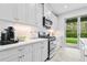 Kitchen with white cabinets, stainless steel appliances, and backyard view at 3543 Woodmont Dr, Parrish, FL 34219