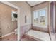 Bathroom featuring garden tub with shuttered window and view of the outdoors, adjacent to private toilet at 5245 88Th E St, Bradenton, FL 34211