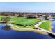 Aerial view of golf practice area with golfers, lush fairways, water hazards, and golf carts at 5245 88Th E St, Bradenton, FL 34211