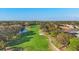 Aerial view of a green golf course with trees and a water hazard adjacent to the fairway at 5245 88Th E St, Bradenton, FL 34211