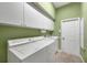 Laundry room featuring white washer and dryer, white cabinets and green walls at 5245 88Th E St, Bradenton, FL 34211