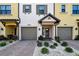 Townhome exterior showcasing gray garage doors, and well-manicured landscaping at 5560 Cannes Cir # 3-106, Sarasota, FL 34231
