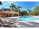 Community pool and lounge area with palm trees at 5560 Cannes Cir # 3-106, Sarasota, FL 34231