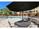 Poolside patio furniture under umbrella for shade at 5560 Cannes Cir # 3-106, Sarasota, FL 34231