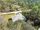 Aerial view of single-story home with gray roof, surrounded by lush green landscape at 5629 Crenshaw Ln, North Port, FL 34286