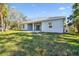 Home exterior showcasing a covered patio and grassy backyard at 5629 Crenshaw Ln, North Port, FL 34286