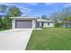 Newly constructed home with a gray exterior, attached garage, and well-manicured lawn at 5629 Crenshaw Ln, North Port, FL 34286