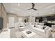 Modern living room with open kitchen, staged furniture, and ceiling fan at 5629 Crenshaw Ln, North Port, FL 34286