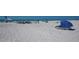 Beach scene with people relaxing under umbrellas at 6144 Midnight Pass Rd # 2N, Sarasota, FL 34242