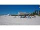Beachfront view of white sand and beach shelter at 6144 Midnight Pass Rd # 2N, Sarasota, FL 34242