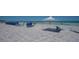 Beach view with lounge chairs and white canopy at 6144 Midnight Pass Rd # 2N, Sarasota, FL 34242