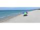 Relaxing beach scene with a colorful umbrella at 6144 Midnight Pass Rd # 2N, Sarasota, FL 34242