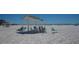 Beachfront view with a shaded seating area at 6144 Midnight Pass Rd # 2N, Sarasota, FL 34242