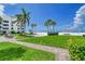 Pathway to beach; lush landscaping, palm trees, and resort building in background at 6144 Midnight Pass Rd # 2N, Sarasota, FL 34242