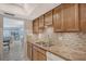 View of kitchen sink and countertops, wood cabinets, and tile backsplash at 6144 Midnight Pass Rd # 2N, Sarasota, FL 34242