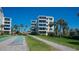 Outdoor shuffleboard with brick pathway, green space, and condo building at 6144 Midnight Pass Rd # 2N, Sarasota, FL 34242