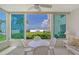 Bright sunroom with table and chairs, offering stunning ocean views at 6144 Midnight Pass Rd # 2N, Sarasota, FL 34242