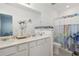 Bright bathroom with double sinks, white cabinets, and a shower at 6404 Silverstar Dr, Sarasota, FL 34240