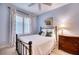 Bright bedroom with a comfortable bed, wooden dresser, and window seating at 6450 Watercrest Way # 303, Lakewood Ranch, FL 34202