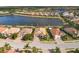 Aerial view of lakefront homes with tile roofs in a luxury community at 7014 Whittlebury Trl, Lakewood Ranch, FL 34202