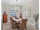 Elegant dining room with a large wooden table and wicker chairs at 7014 Whittlebury Trl, Lakewood Ranch, FL 34202