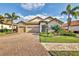 Single-story home with stone accents, tile roof, and a paved driveway at 7014 Whittlebury Trl, Lakewood Ranch, FL 34202