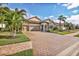 Landscaped property featuring a brick driveway and palm trees at 7014 Whittlebury Trl, Lakewood Ranch, FL 34202
