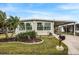 Single-wide manufactured home with landscaped yard and carport at 716 Blackburn Blvd, North Port, FL 34287