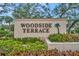 Woodside Terrace entrance sign with lush landscaping at 7167 Wood Creek Dr # 3, Sarasota, FL 34231