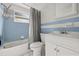 Clean bathroom with light blue tiled walls, white vanity and bathtub at 9066 Oneal Ave, New Port Richey, FL 34654