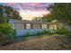 Charming ranch home with a tree-lined yard at sunset at 9066 Oneal Ave, New Port Richey, FL 34654