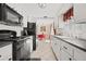Long kitchen with white cabinets, black appliances, and view to dining area at 9066 Oneal Ave, New Port Richey, FL 34654