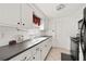 White kitchen cabinets, black appliances, and a galley-style layout at 9066 Oneal Ave, New Port Richey, FL 34654