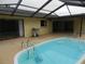 Inviting kidney-shaped pool with steps and screened enclosure at 9400 Ridge Rd, Seminole, FL 33772