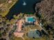 Aerial view showing community pool, tennis courts, playground, and clubhouse near a lake at 9481 Highland Oak Dr # 1403, Tampa, FL 33647