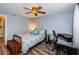 Bright bedroom with a queen bed, desk, and wood-look floors at 9481 Highland Oak Dr # 1403, Tampa, FL 33647