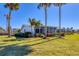 White house with screened porch, landscaping, and palm trees at 100 The Esplanade N # 1, Venice, FL 34285
