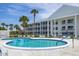 Community pool with surrounding patio furniture at 100 The Esplanade N # 1, Venice, FL 34285