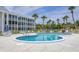 Kidney-shaped community pool with lounge chairs at 100 The Esplanade N # 1, Venice, FL 34285