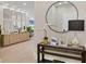 Elegant entryway with a console table, large round mirror, and a modern lamp at 10114 Glenmore Ave, Bradenton, FL 34202