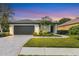 Single-story home with a gray garage door, landscaping, and a paved walkway at 10114 Glenmore Ave, Bradenton, FL 34202