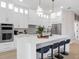 Modern white kitchen with stainless steel appliances and an island with seating at 10114 Glenmore Ave, Bradenton, FL 34202