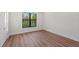 Well-lit bedroom featuring wood-look floors and a window at 11323 Rivers Bluff Cir, Lakewood Ranch, FL 34202