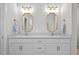 Double vanity bathroom with white cabinets and gold framed mirrors at 11628 Middle Fork Way, Parrish, FL 34219