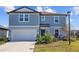 Two story house, gray siding, attached garage, and front yard at 11628 Middle Fork Way, Parrish, FL 34219